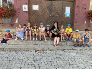 Kinder und Lehrerin sitzen mit einem Eis in der Hand auf der Rathaustreppe