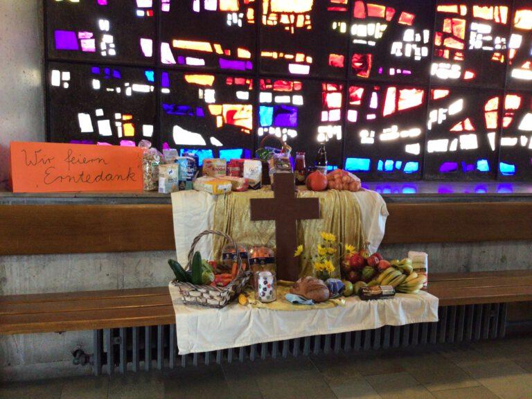 Nachgebauter Altar auf einer BAnk mit Kreuz und Obst und Gemüse