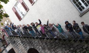 Eine Schulklasse steht auf den Treppenstufen eines Turmes