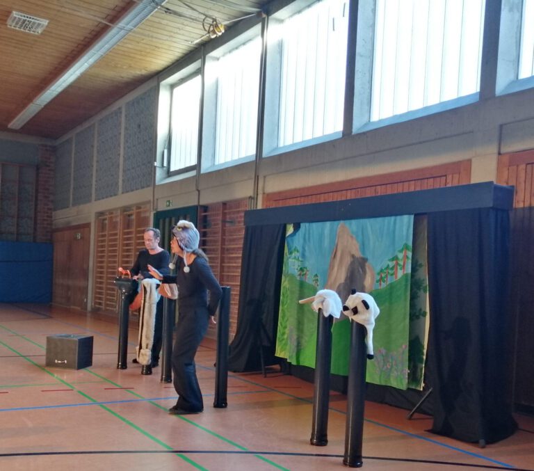 Kinder sitzen in der Turnhalle