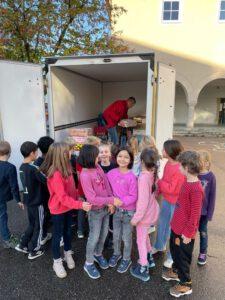 Kinder stehen mit den Päckchen vor einem LKW