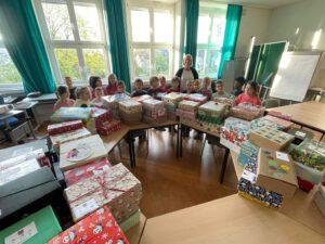 Viele Kinder stehen hinter gepackten Päckchen