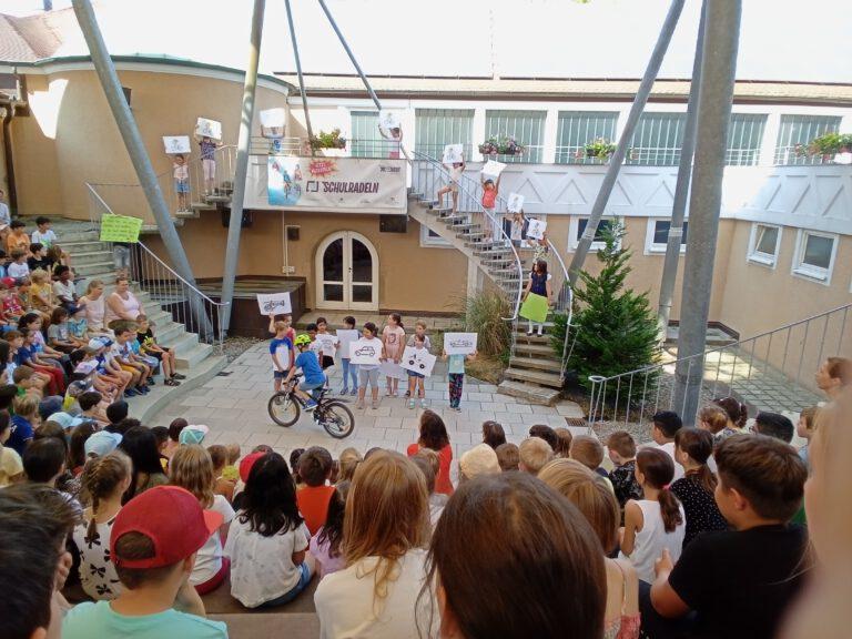 Junge mit Fahrrade bei Versammlung im Atrium