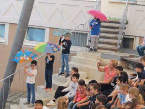 Kinder tanzen mit Regenschirm im Atrium