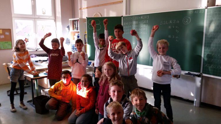 Jubelnde Kinder mit Apfel in der HAnd