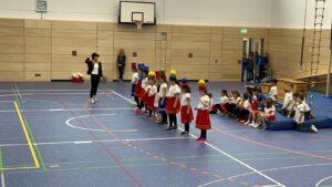 Kinder mit Reifen und Ball auf dem Kopf