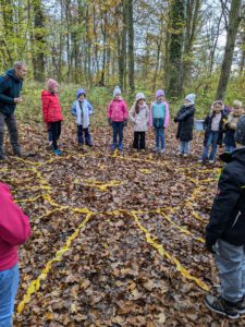 Kinder mit dem Förster im Wald